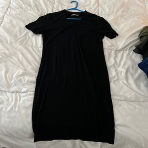 Long, large, black dress with short sleeves, V cut out in chest and small slit